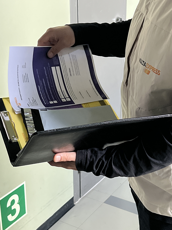Asiakas luovuttaa kultakorut KultaExpressin lähetille